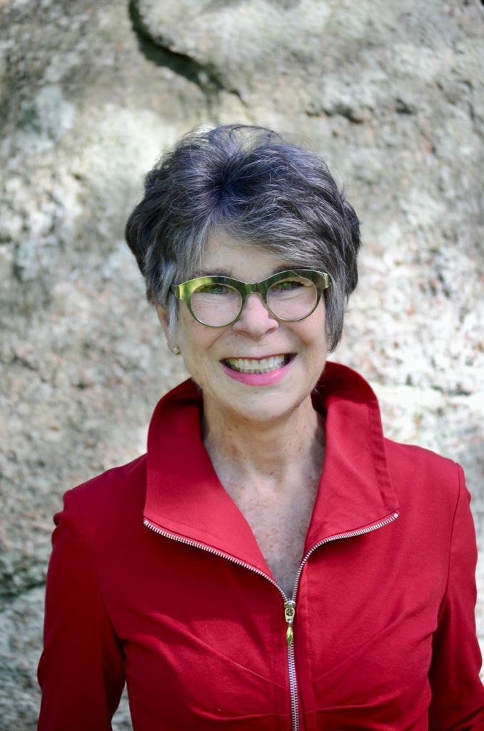 Halina St James smiles, wearing a red shirt